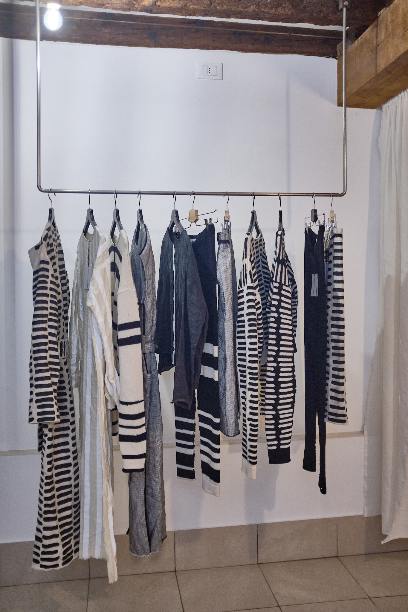 Inside of shop with black and white clothing hanging on a rail